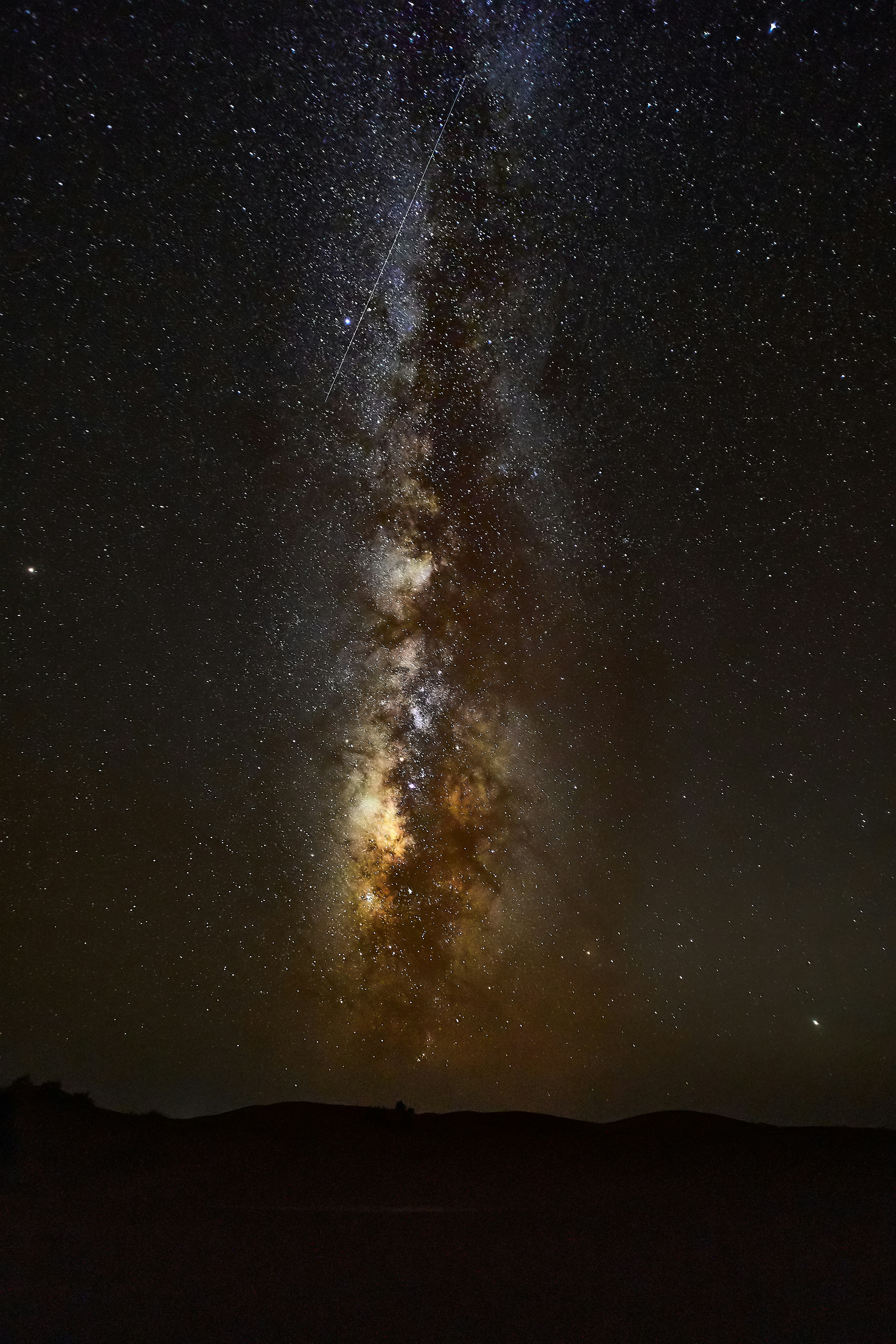 silhouette of mountain under starry night